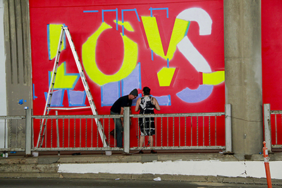 Photo of local urban artists painting murals under the I-70 viaduct during the 'duct-work Event (September 30, 2016).
