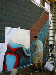 Photo of a local urban artist painting a mural under the I-70 viaduct during the 'duct-work Event (September 30, 2016).