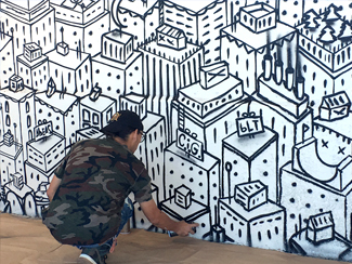 Photo of a local urban artist painting a mural under the I-70 viaduct during the 'duct-work Event (September 30, 2016).