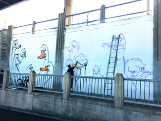 Photo of a local urban artist painting a mural under the I-70 viaduct during the 'duct-work Event (September 30, 2016).